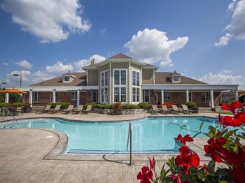 A large house with a pool in front.